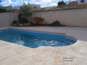 Rénovation d'une plage de piscine en béton imprimé ton pierre.